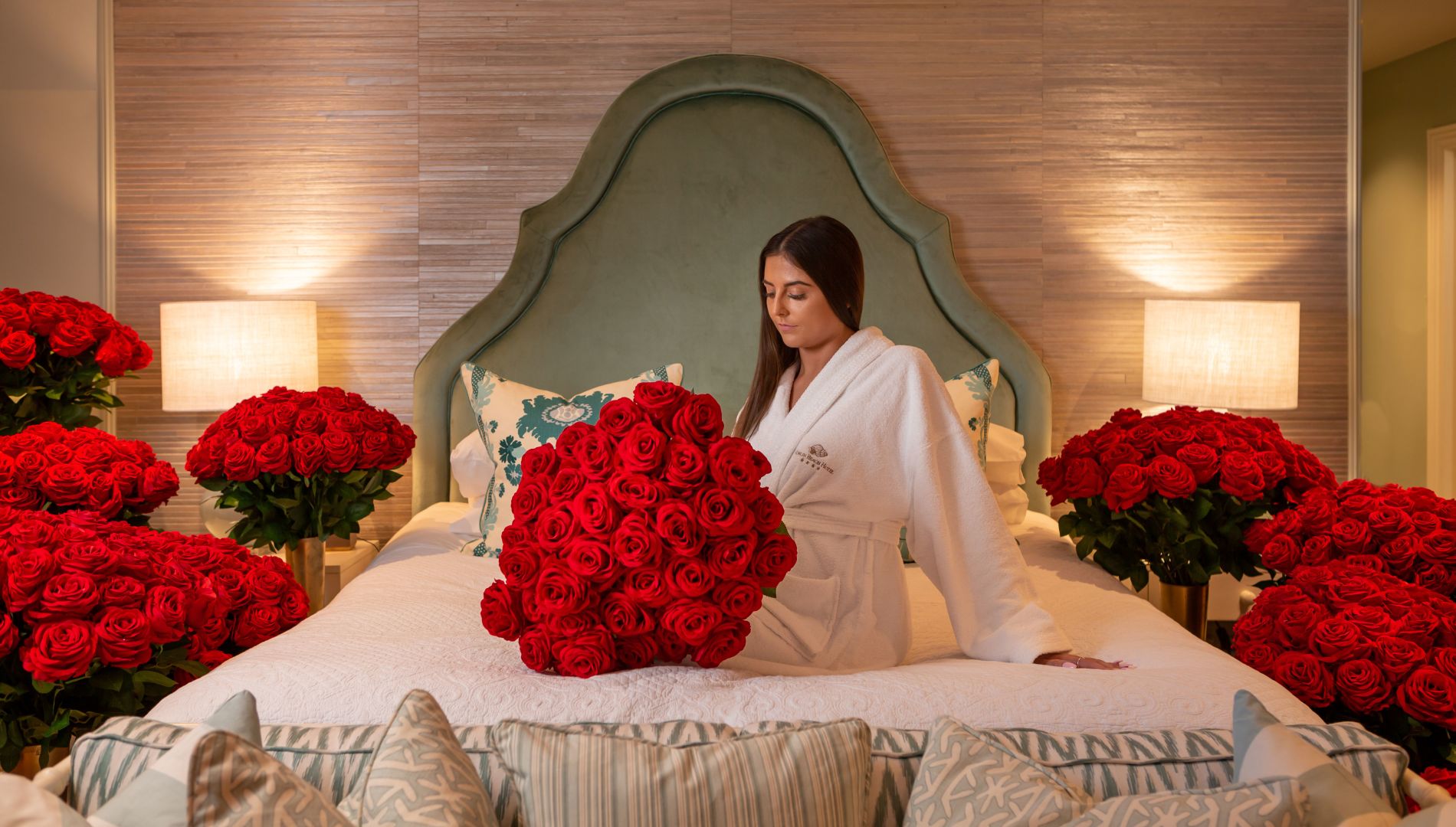 A Person Sitting On A Bed With A Red Flower