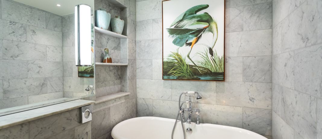 A Bathroom With A Painting On The Wall